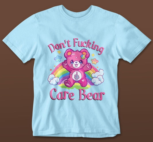 Light blue t-shirt with a pink Care Bear graphic and text on a brown background